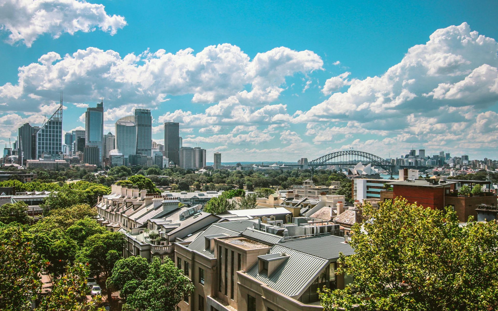 Stunning view of Sydney's skyline featuring the Harbour Bridge and Opera House under a clear blue sky.